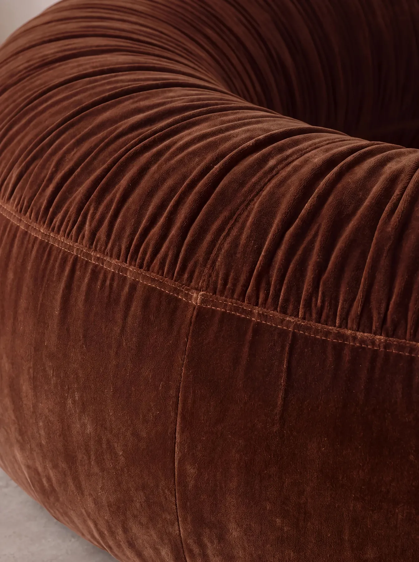 Close view of the ruched terracotta velvet of the Donut Seat