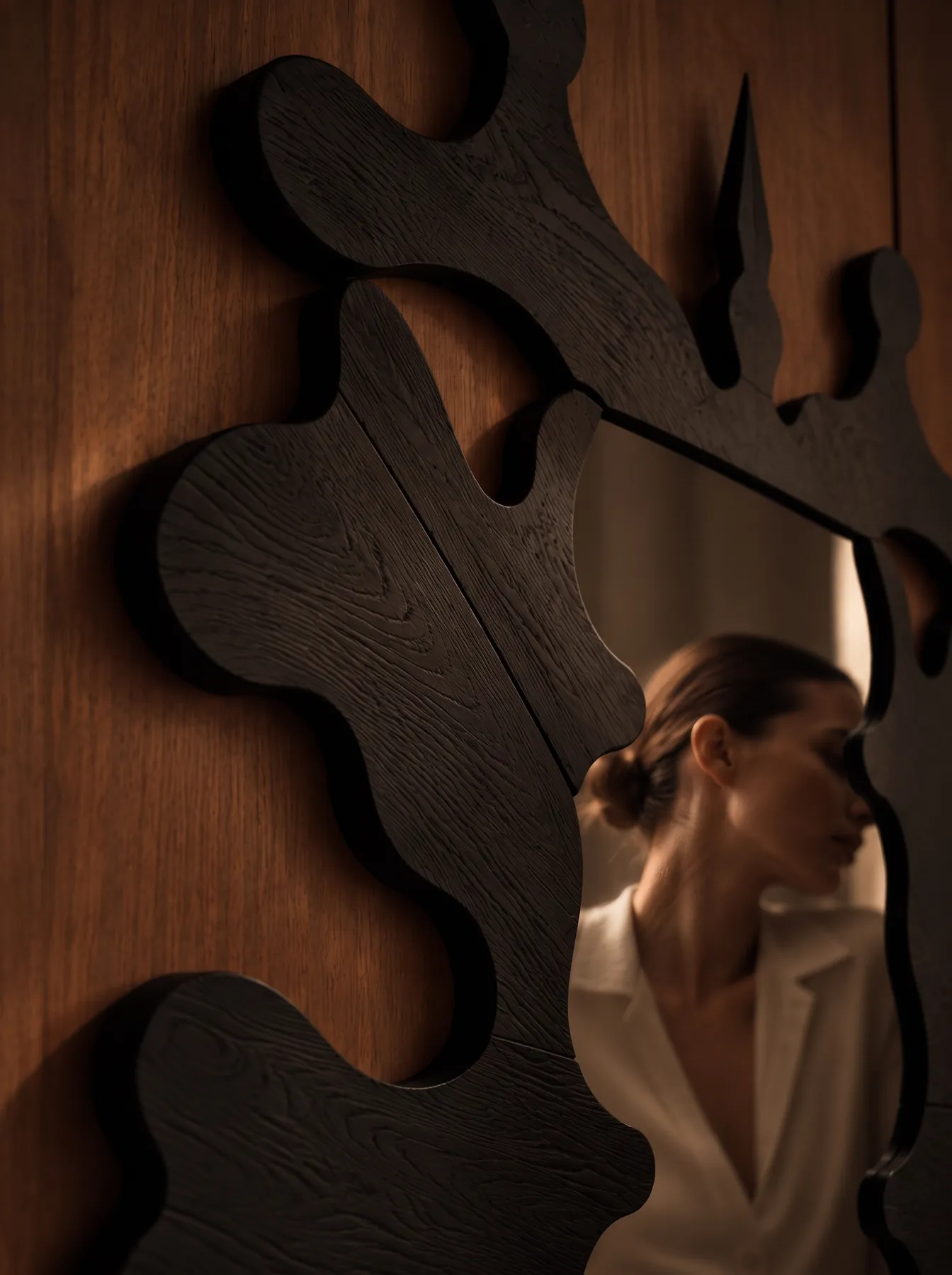 Close view of the Inkblot Mirror reflecting a woman in a white blazer