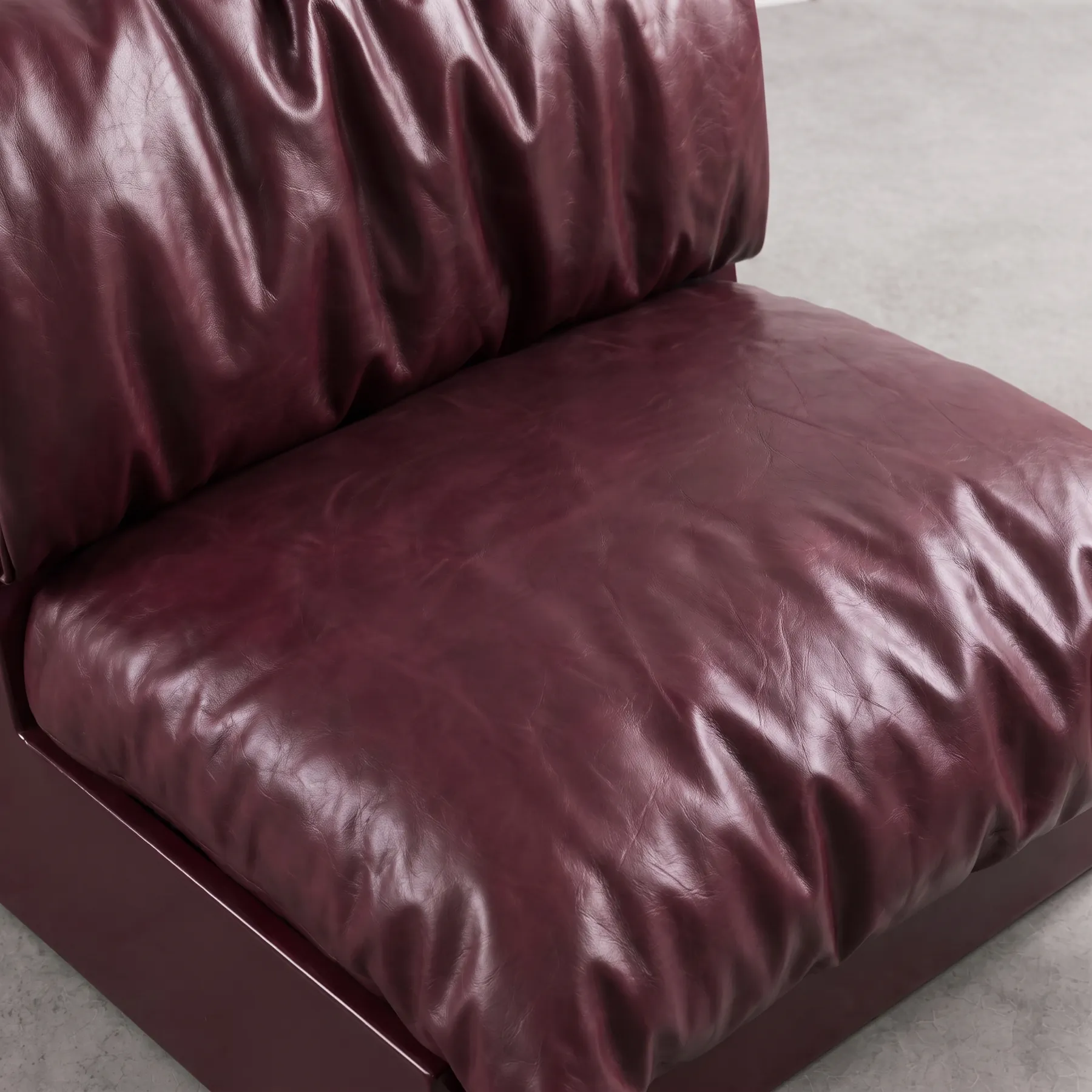 Close view of the glossy burgundy leather folds of the Undone Seat